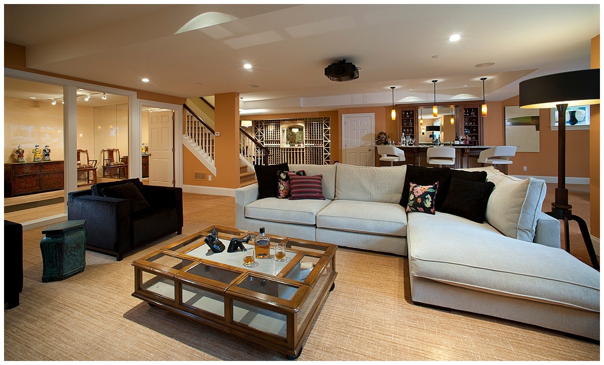 A photo of an open plan part of a home with living room, kitchen, and stairwell.