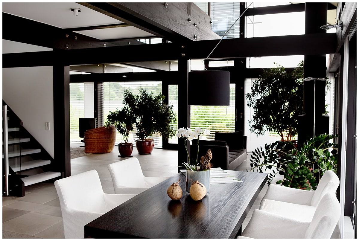 Dining room with black ceiling beams, black wooden pillars, black ceiling lamp, and black dining table