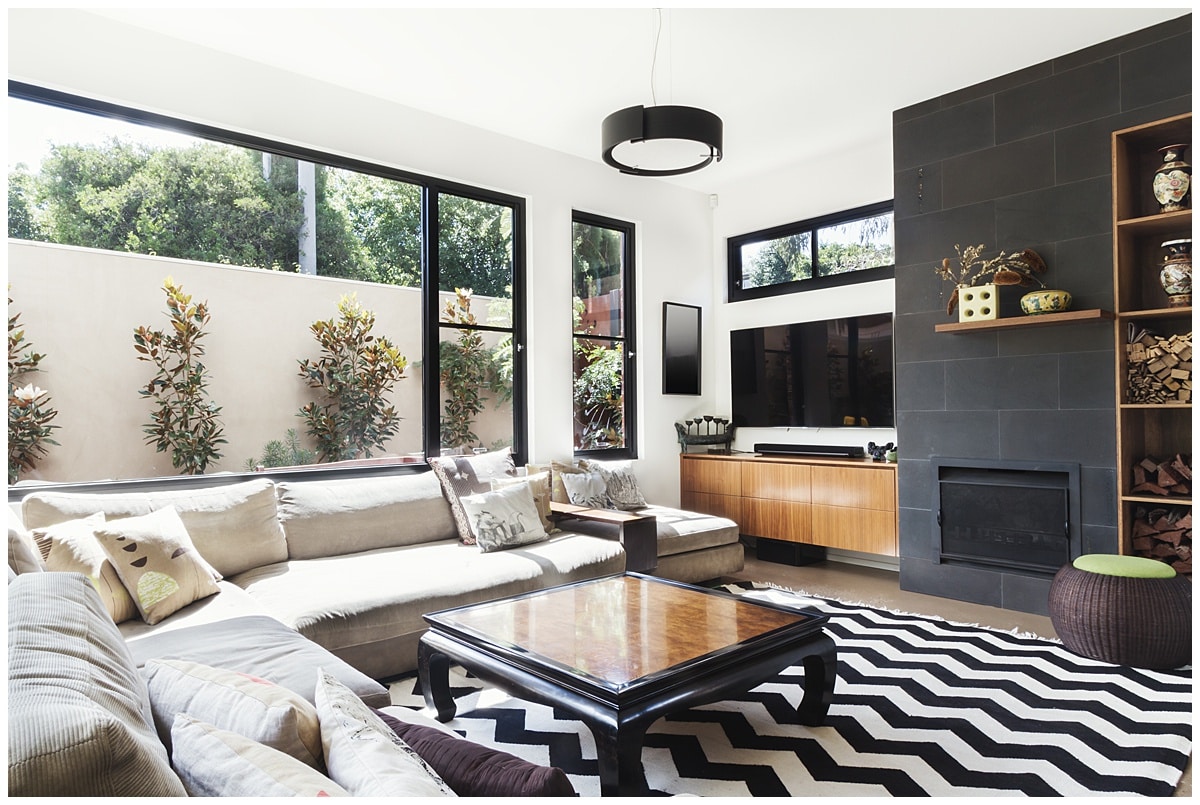 Living room with black window trim, black wall, and black and white zigzag rug