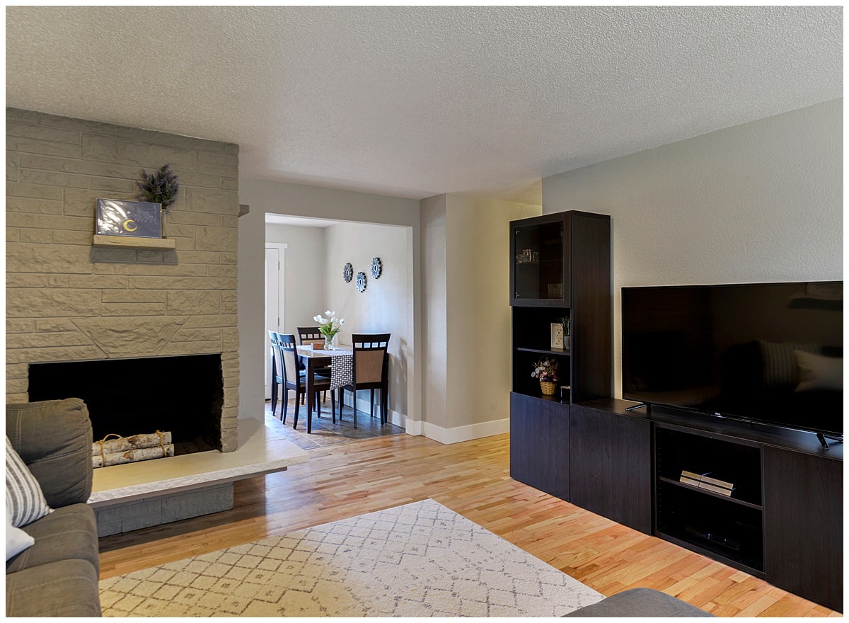 Open living room with fireplace in the back and sofa facing tv on stand